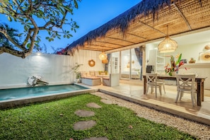 A pool area with a thatched roof, a dining table with chairs, and a seating area with cushions. - Maison 246 2BR Cozy Private Pool Villa In Vibrant Canggu (Badung)