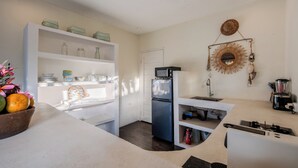 Eine kleine Küche mit Kühlschrank, Mikrowelle und Kaffeemaschine.