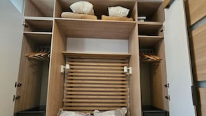 A bedroom with a bed, a wardrobe, and a shelf with pillows. - Alpine Retreat With Balcony and Parking (Saint-Sorlin-d'Arves)