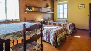 Ein Zimmer mit zwei Betten, Holzbalken an der Decke, einem Fenster und einer Heizung.