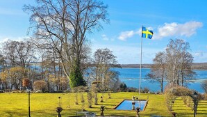 Un parco con una bandiera, una piscina e vista sull'acqua.