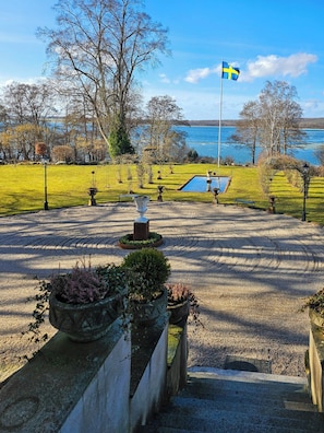 A park with a flag, a pool, and a view of the water. - Villa with own jetty by limestone lake in Balsvik (Kristianstad)