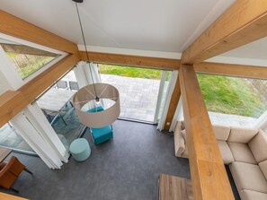A modern interior with a large window, a hanging light fixture, and a sofa. - DuinZilver A by Interhome (Renesse)