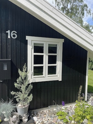 A black building with a white window and the number 16 on the wall. - Summerhouse with hot tub on Langeland (Tranekær)
