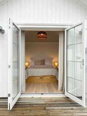 Ein Schlafzimmer mit einem Bett, Nachttischlampen und einer Pendelleuchte.