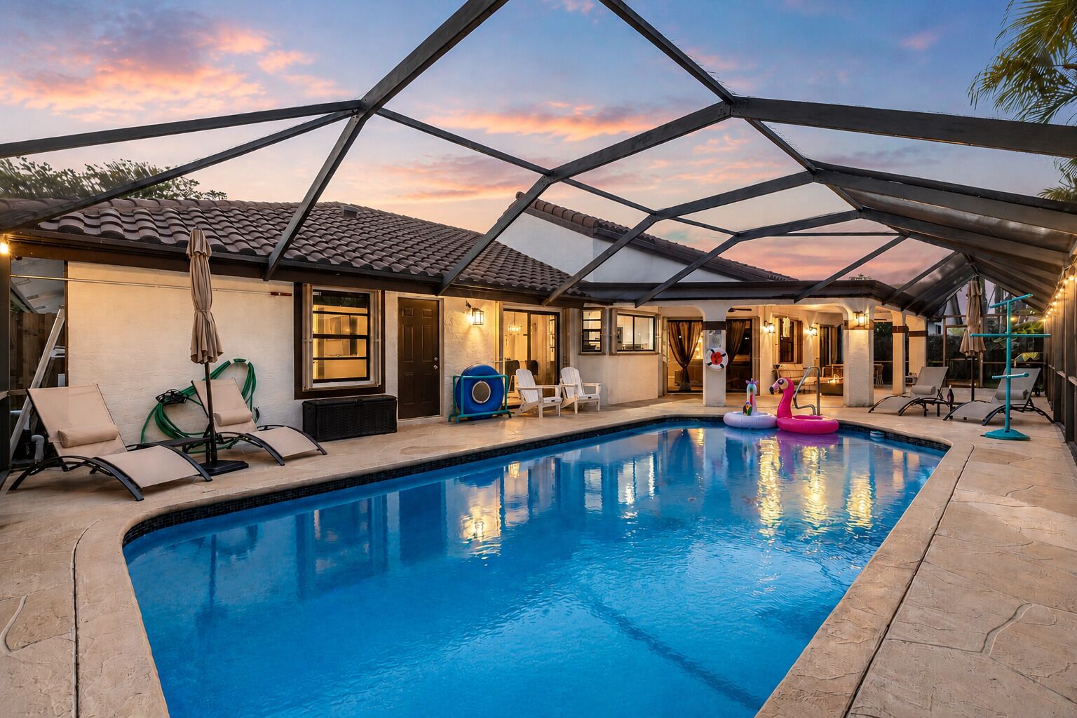 Uma piscina com espreguiçadeiras e um terraço coberto.
