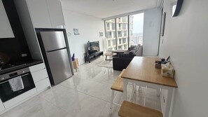 Une cuisine moderne équipée d’un réfrigérateur, d’un four et d’un coin repas avec une table et des chaises.