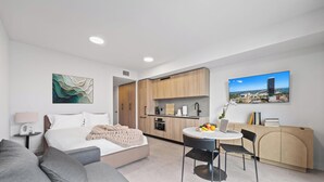 A modern hotel room with a bed, a desk, a dining table, and a kitchen area. - Downtown Miami near Science&Art Museums (Miami)