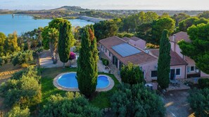 Una proprietà residenziale con piscina, pannelli solari e vista su un lago.