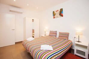 A hotel room with a bed, bedside tables, a wardrobe, and a painting on the wall. - Barcelona center family apartment 7 (Barcelona)