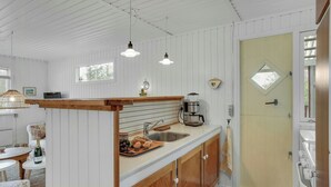 A kitchen with a wooden counter, a sink, and a coffee maker. There is a door with a window and a towel hanging on it. - Charm and idyll in Hou (Hals)