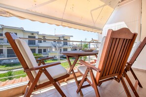A balcony with two wooden chairs and a small table, overlooking a residential area. - Ammos Premium Apartment by RentalsPro - Fourka Halkidiki (Fourka)