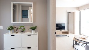 Een moderne badkamer met een witte wastafel, een spiegel en drie planten in potten.