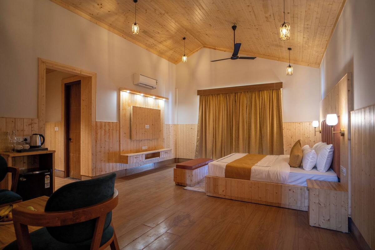 A wooden interior with a bed, a desk, and a chair.