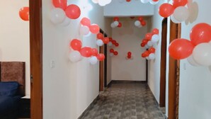 Un pasillo con piso estampado, paredes blancas y globos rojos y blancos.