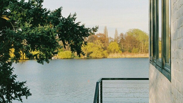 A view of a lake from a building with a staircase leading to a balcony. - Bauhaus studio with Havel river views in Werder (Werder (Havel))