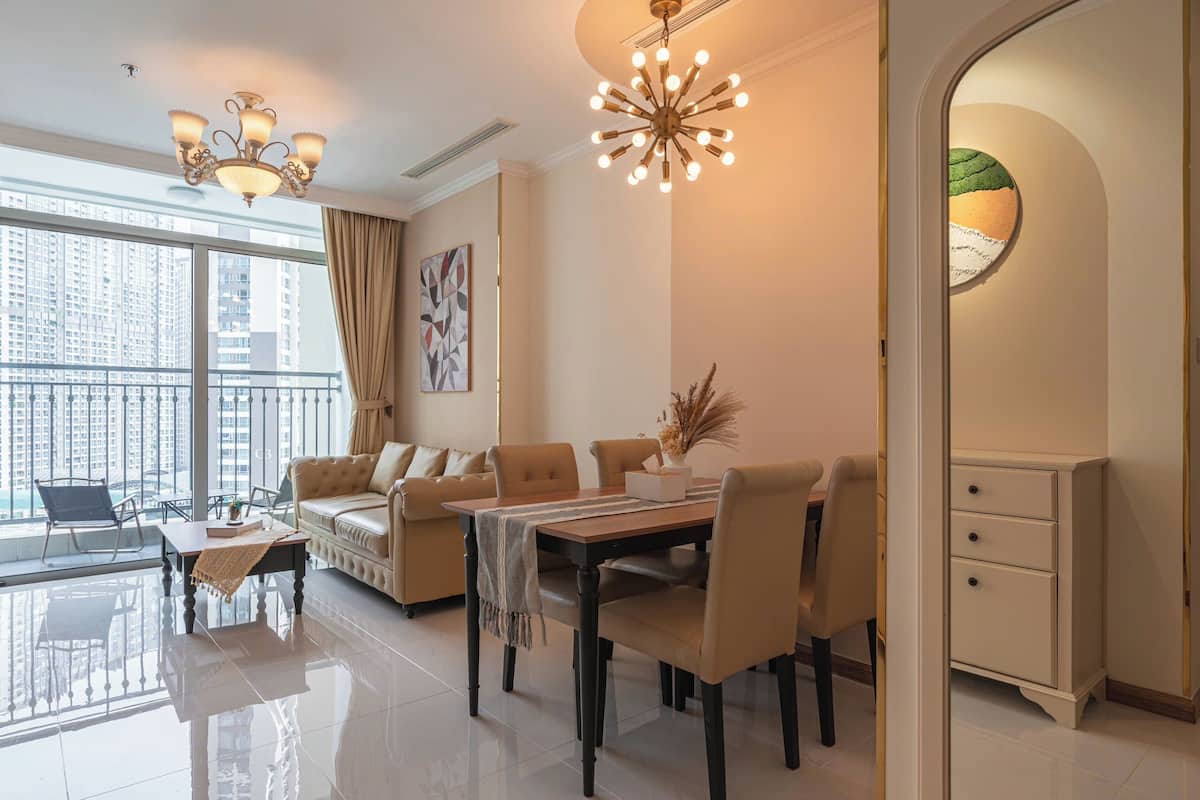 Una sala de estar moderna con una mesa de comedor, sofás y una araña.