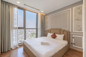 Una camera d'albergo con un'ampia finestra, un letto e vista sulla città.