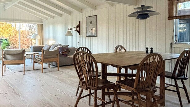 En matplats med ett träbord och stolar, en soffa och en lampa.