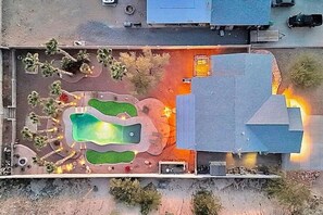 Eine Vogelperspektive zeigt eine Wohngegend mit Schwimmbad, Terrasse und angrenzenden Gebäuden.