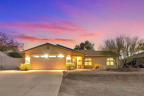 A two-story house with a garage, a driveway, and a landscaped front yard. - Epic Pool Resort | Pickleball & Basketball Court (Fort Mohave)