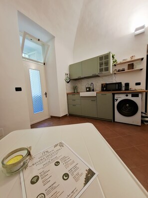 A kitchen with a washing machine, a microwave, and a sink. - Finale Natura House: Your House in the nature of Finale Ligure (Liguria)