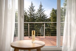 A balcony with a glass bottle on a wooden table, overlooking a railing and trees. - Room 'Einzelzimmer Mit Eigenem WC Und Gemeinschaftsküche.' with Wi-Fi (Lübeck)