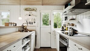 Una cucina con mobili in legno, un lavello e un fornello.