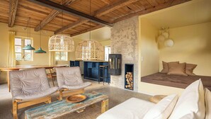 Una sala de estar acogedora con un sofá, sillones, una mesa de centro y una chimenea.