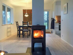 Ein modernes Interieur mit Kaminofen, Essbereich und Küche.