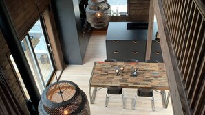 Een modern loft-interieur met een eethoek, keuken en zithoek.