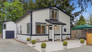 Un bâtiment à deux étages doté d’un patio couvert, d’un garage et d’un espace extérieur clôturé.