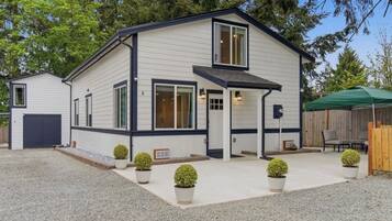 A two-story building with a covered patio, a garage, and a fenced outdoor area.