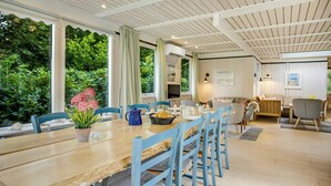 A dining area with a wooden table, blue chairs, and a potted plant.