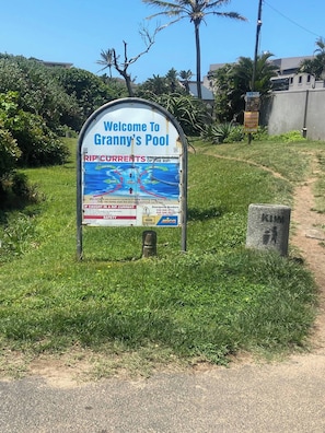 A sign welcoming visitors to Granny's Pool with safety information and emergency numbers. - Stylish 2BR in Salt Rock - Sheffield Hills (Ballito)