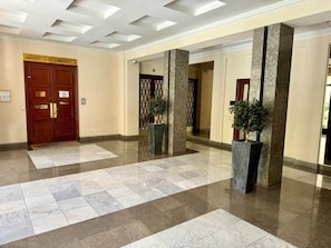 A lobby with a marble floor, a wooden door labeled 'CHAMBRE DES NOTAIRES,' and two potted plants. - Ambassador Promenade! (Nice)