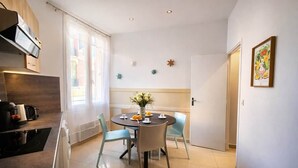 Et moderne køkken med spiseplads, indbygget ovn og et vindue med gardiner.