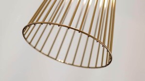 Een metalen, ribbelige, cilindrische lamp.