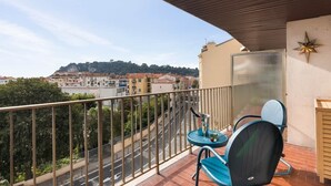 Een balkon met uitzicht op een stadsgezicht, een tafel met stoelen en een ster decoratie aan de muur.