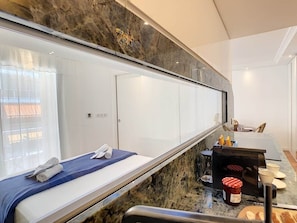 A hotel room with a bed, a bathroom, a small kitchen area, and a large mirror. - BLUE RIVIERA TERRACE CENTRAL TRAIN STATION (Nice)