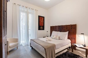 A bedroom with a large bed, a chair, a nightstand, a lamp, and a window with curtains. - Home Art - Central, fantastic garden and quiet (Nice)