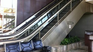 Una escalera mecánica interior con un cartel que indica acceso al 'Bureau de l'Escalier' y la 'Salle'.