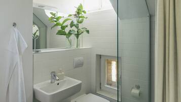 A bathroom with a sink, toilet, and a glass shower enclosure.