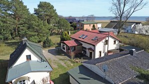 Bairro residencial com casas, gramado e um corpo d'água ao fundo.