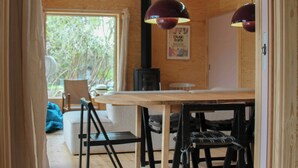 Puisesti sisustettu tila, jossa on ruokapöytä, tuoleja ja riippuvalaisimia.