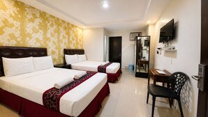 A hotel room with two beds, a desk, a chair, a TV, and a mirror. - Obrero Suites Davao (Davao)