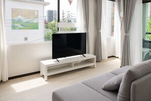 Apartamento família, sacada, vista para o parque | Área de estar