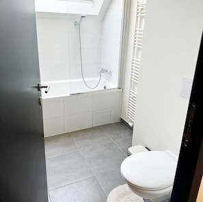 Ein Badezimmer mit Badewanne, Toilette und Dusche.