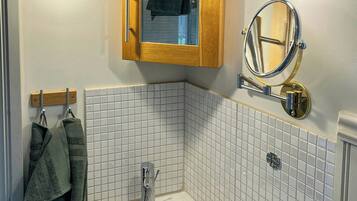 A bathroom with a white sink, a wooden cabinet with a mirror, and two wall-mounted lights.