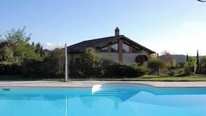 A swimming pool with a house in the background. - Villa with private pool among Siena's olive groves (Rapolano Terme)